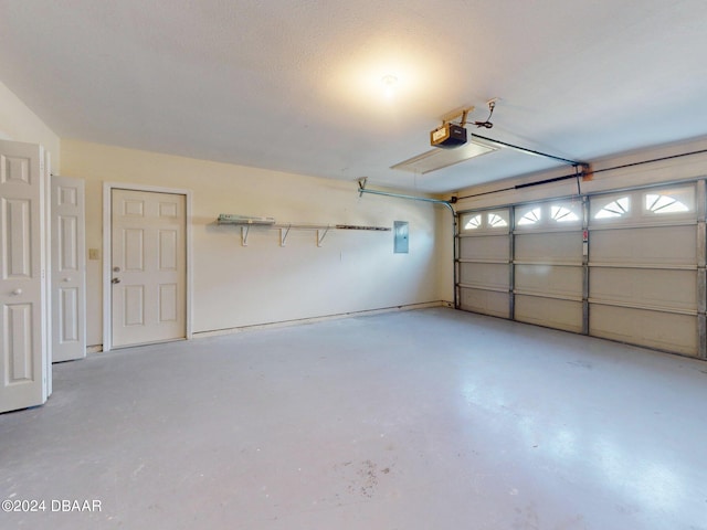 garage with electric panel and a garage door opener