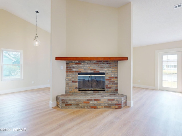 804 Soft Pine Ct, New Smyrna Beach, FL 32168 - unfurnished living room featuring wood finished floors, high vaulted ceiling, baseboards, and a brick fireplace