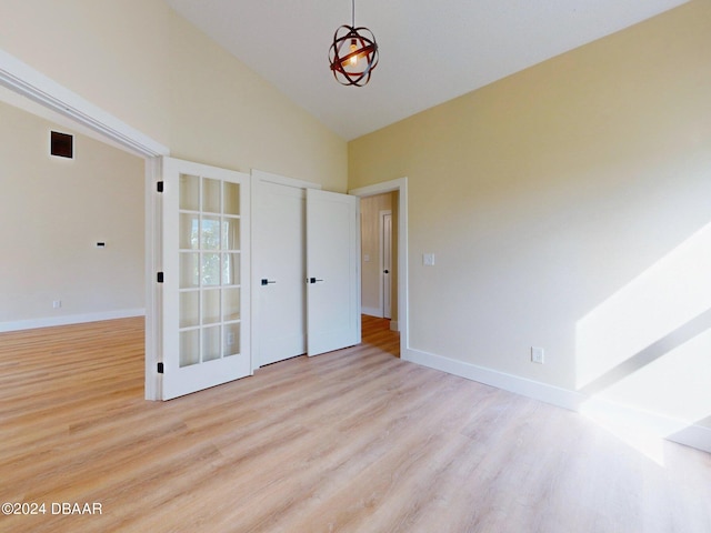 interior space with light wood-type flooring and high vaulted ceiling