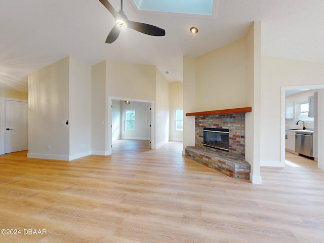 unfurnished living room with plenty of natural light, ceiling fan, a fireplace, and light hardwood / wood-style flooring