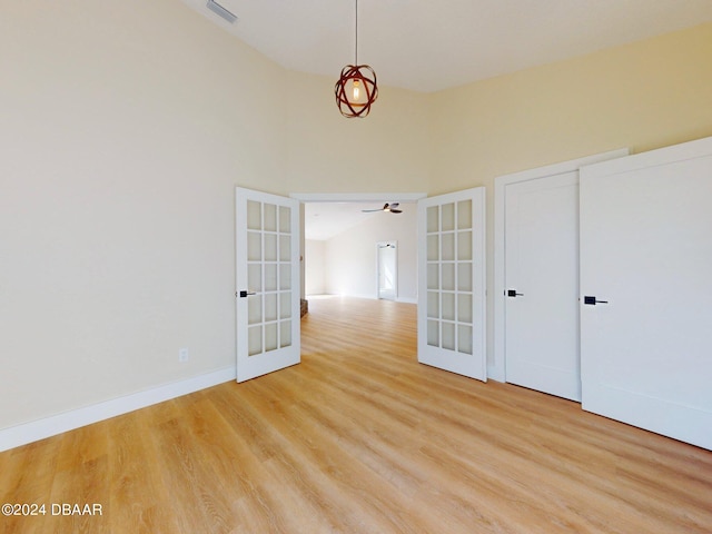 spare room with french doors, high vaulted ceiling, light hardwood / wood-style flooring, and ceiling fan