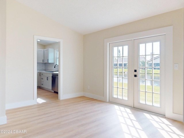 doorway to outside with french doors, light wood-type flooring, lofted ceiling, and sink