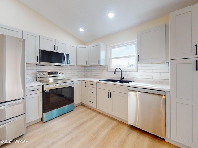 804 Soft Pine Ct, New Smyrna Beach, FL 32168 - kitchen with appliances with stainless steel finishes, a sink, tasteful backsplash, light countertops, and lofted ceiling