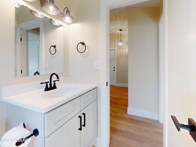 bathroom with vanity, a notable chandelier, and hardwood / wood-style flooring