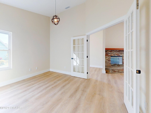 804 Soft Pine Ct, New Smyrna Beach, FL 32168 - empty room featuring wood finished floors, a fireplace, french doors, and baseboards