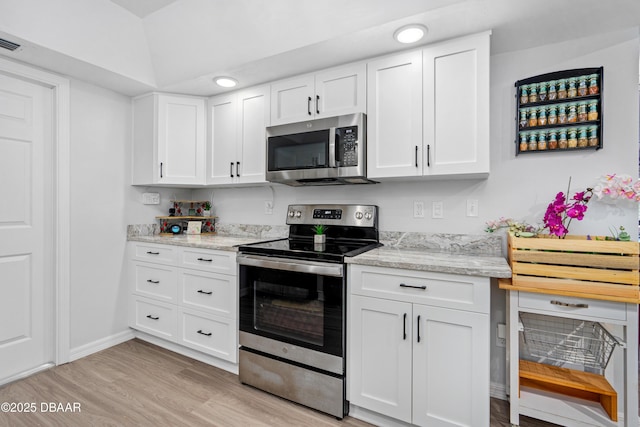 kitchen featuring light stone counters, recessed lighting, light wood-style flooring, appliances with stainless steel finishes, and white cabinets