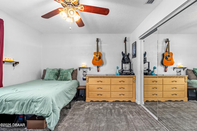 carpeted bedroom featuring a ceiling fan, a closet, and a textured ceiling