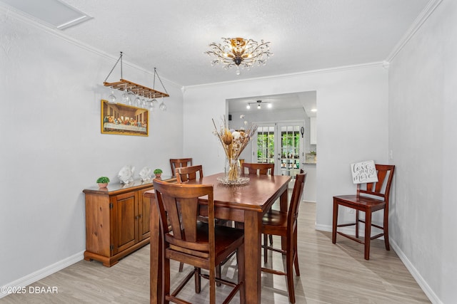 dining space featuring light wood-style flooring, visible vents, baseboards, french doors, and crown molding