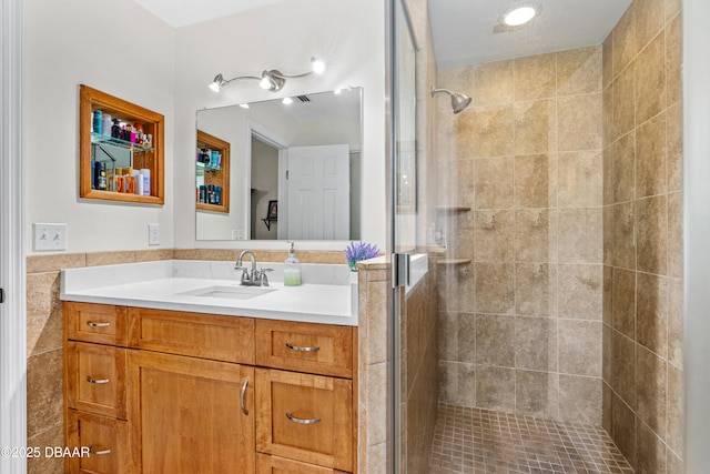 bathroom featuring a stall shower, tile walls, and vanity