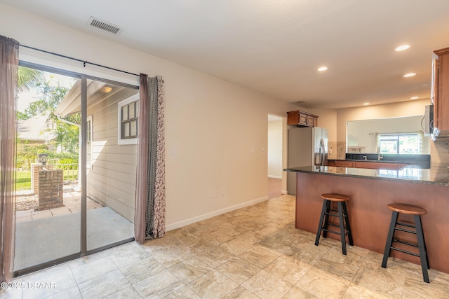 2017 Cornell Pl, Port Orange, FL 32128 - kitchen featuring a peninsula, a kitchen breakfast bar, recessed lighting, appliances with stainless steel finishes, and dark stone counters