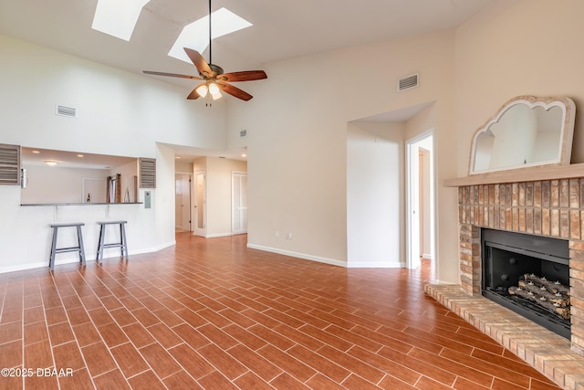 2017 Cornell Pl, Port Orange, FL 32128 - unfurnished living room featuring high vaulted ceiling, a brick fireplace, a skylight, ceiling fan, and wood finished floors