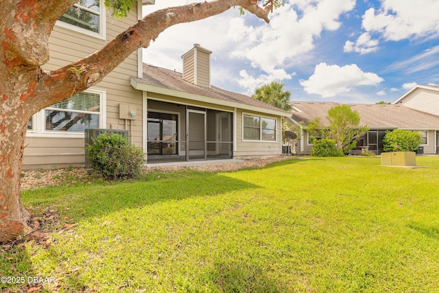 2017 Cornell Pl, Port Orange, FL 32128 - back of house with a yard, a chimney, a sunroom, and a shingled roof