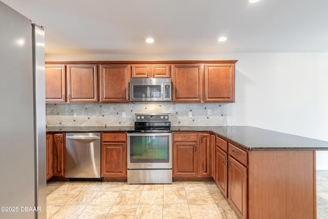 2017 Cornell Pl, Port Orange, FL 32128 - kitchen with stainless steel appliances, a peninsula, decorative backsplash, dark stone counters, and recessed lighting
