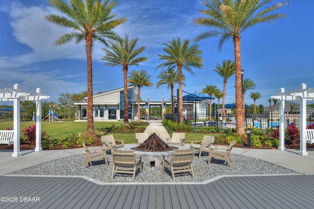 exterior space featuring playground community, fence, a fire pit, and a pergola