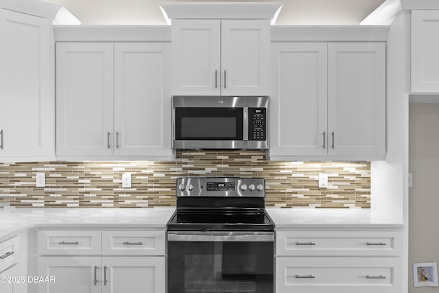 kitchen featuring light stone countertops, tasteful backsplash, white cabinetry, and stainless steel appliances