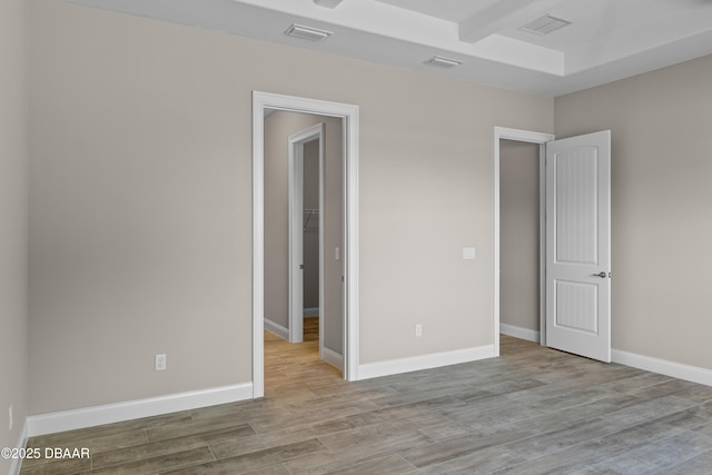 unfurnished bedroom featuring visible vents, baseboards, and wood finished floors