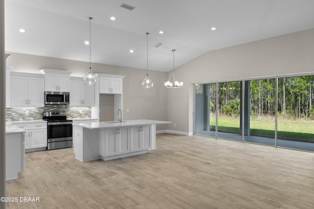 kitchen featuring stainless steel appliances, visible vents, white cabinetry, light countertops, and tasteful backsplash