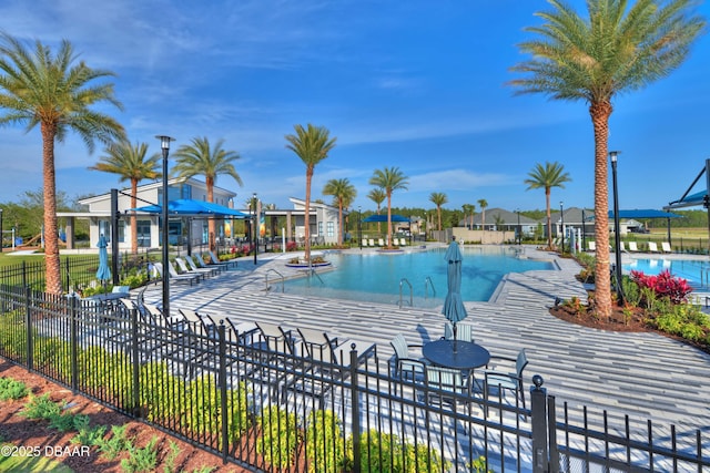 pool with a patio area and fence