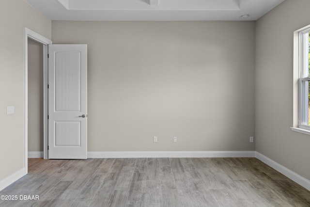 unfurnished room with a healthy amount of sunlight, baseboards, and wood finished floors