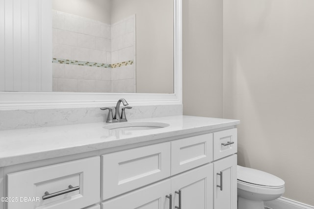 full bathroom featuring toilet, baseboards, and vanity