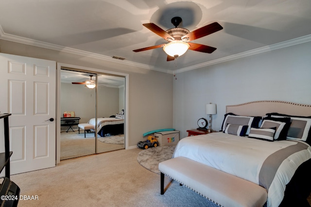 carpeted bedroom featuring ceiling fan, a closet, and crown molding