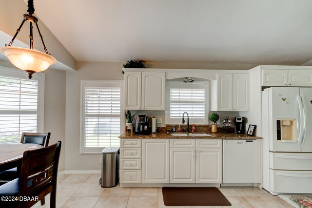 kitchen with white appliances, dark stone countertops, white cabinetry, and sink