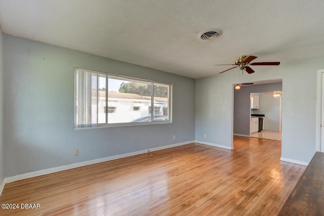 empty room featuring ceiling fan, a textured ceiling, and light hardwood / wood-style floors