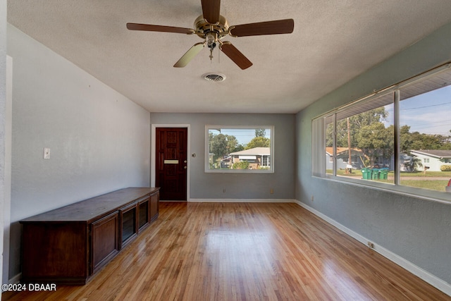 interior space featuring light hardwood / wood-style floors, a textured ceiling, and ceiling fan