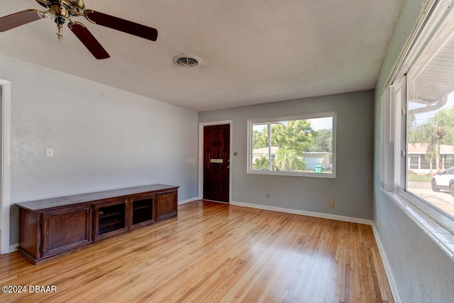 interior space featuring ceiling fan, a textured ceiling, and light hardwood / wood-style flooring