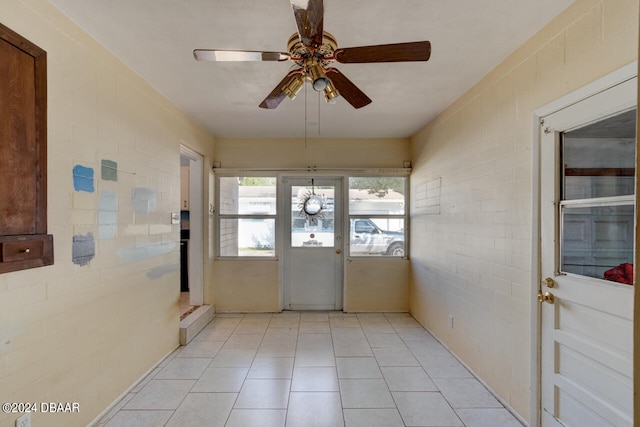 unfurnished sunroom featuring ceiling fan