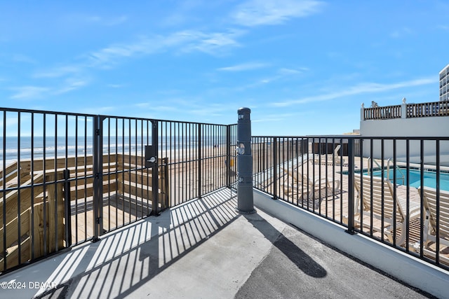 balcony featuring a water view and a beach view