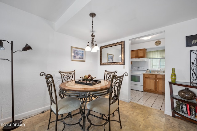 dining space featuring sink and an inviting chandelier