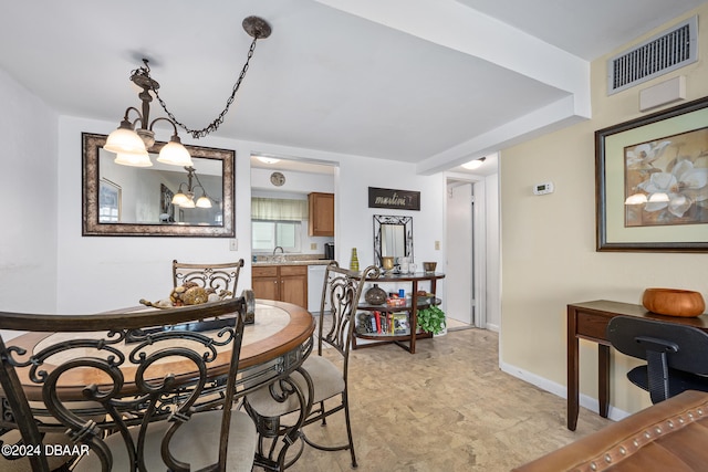 dining space with sink and an inviting chandelier