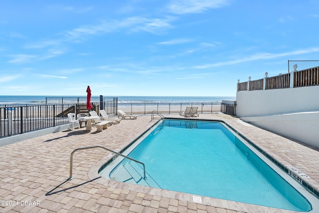 view of pool featuring a water view and a patio area