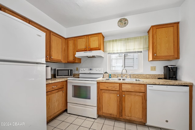 kitchen with white appliances, light tile patterned floors, and sink