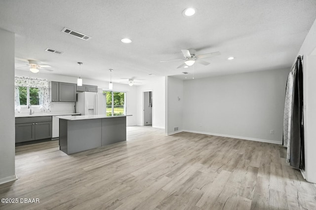 1101 8th St, Daytona Beach, FL 32117 - kitchen featuring white fridge with ice dispenser, a ceiling fan, gray cabinets, a kitchen island, and recessed lighting