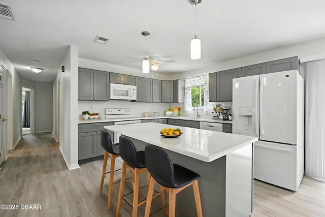 1101 8th St, Daytona Beach, FL 32117 - kitchen with white appliances, gray cabinetry, light wood-style flooring, and light countertops