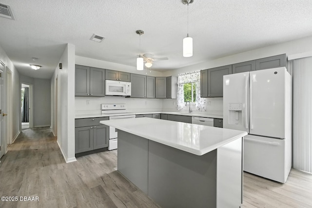 1101 8th St, Daytona Beach, FL 32117 - kitchen with white appliances, gray cabinetry, light countertops, light wood-style floors, and a textured ceiling