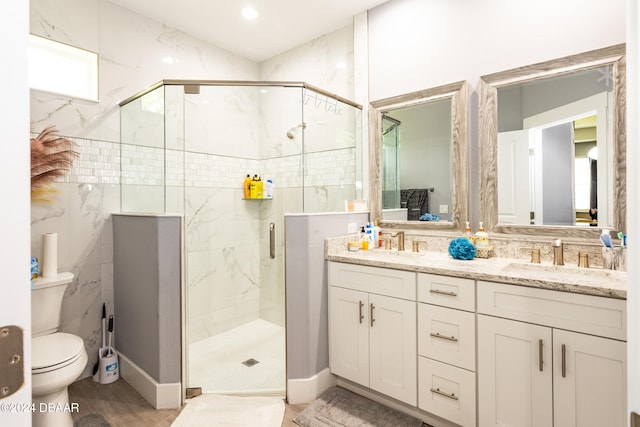 bathroom with hardwood / wood-style floors, vanity, toilet, and a shower with shower door