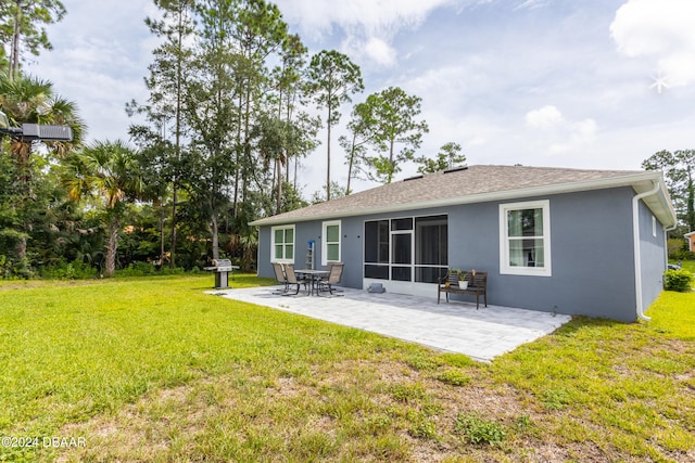 rear view of property featuring a lawn and a patio