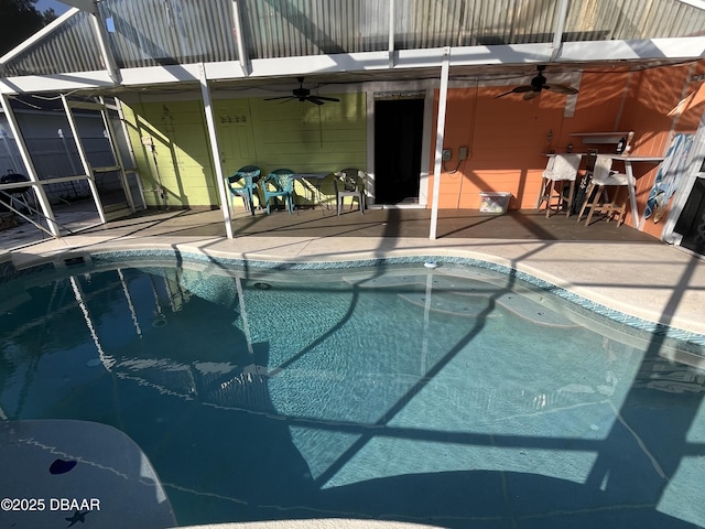 view of pool with ceiling fan, glass enclosure, and a patio