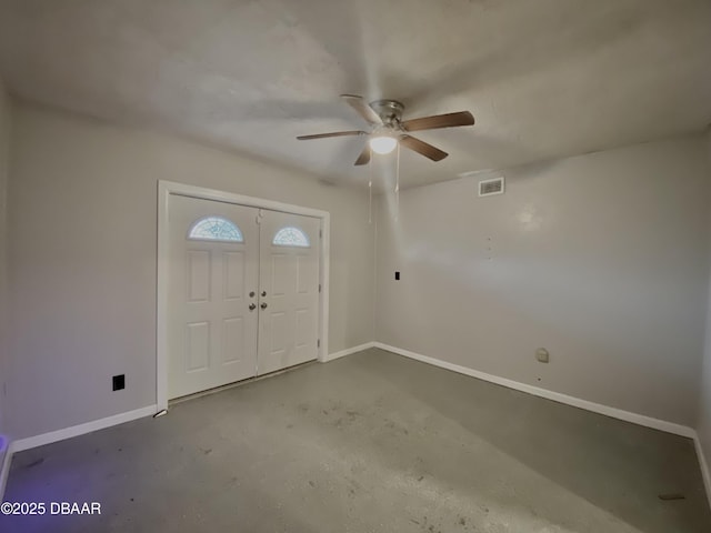 foyer with ceiling fan and concrete flooring