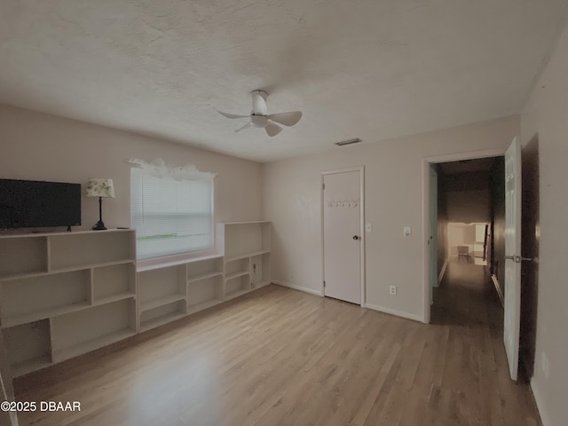 unfurnished bedroom featuring ceiling fan, light hardwood / wood-style floors, and a textured ceiling