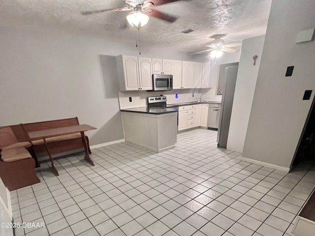 kitchen with ceiling fan, sink, white cabinetry, a textured ceiling, and stainless steel appliances