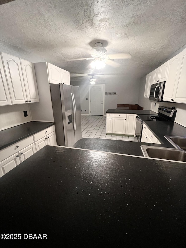 kitchen with sink, stainless steel appliances, white cabinetry, and light tile patterned floors