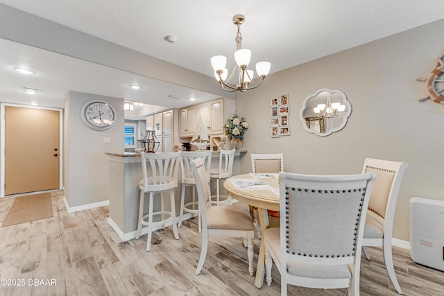 dining room with light hardwood / wood-style flooring and a chandelier