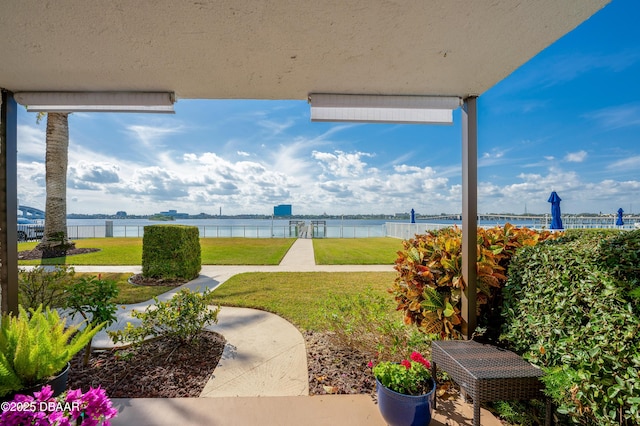 view of patio / terrace featuring a water view and fence