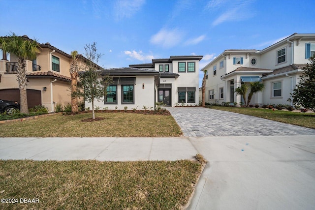 43 Del Palma Dr, Palm Coast, FL 32137 - view of front of property with decorative driveway, a front yard, and stucco siding