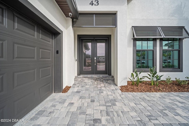 43 Del Palma Dr, Palm Coast, FL 32137 - doorway to property featuring french doors, stucco siding, a garage, and a security system