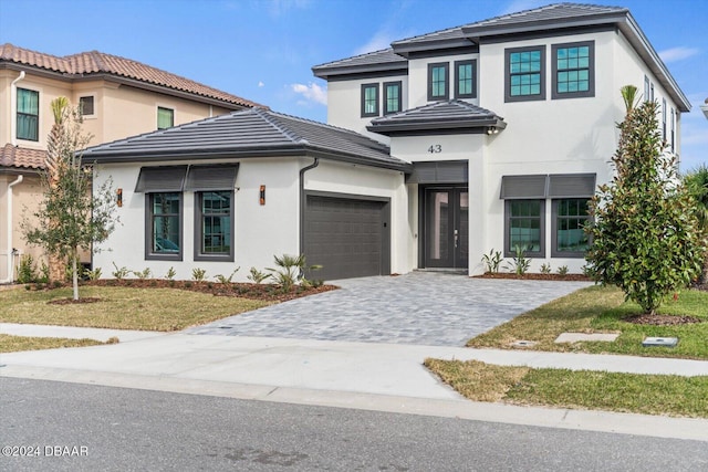 43 Del Palma Dr, Palm Coast, FL 32137 - view of front of property featuring stucco siding, decorative driveway, a front yard, a garage, and a tiled roof